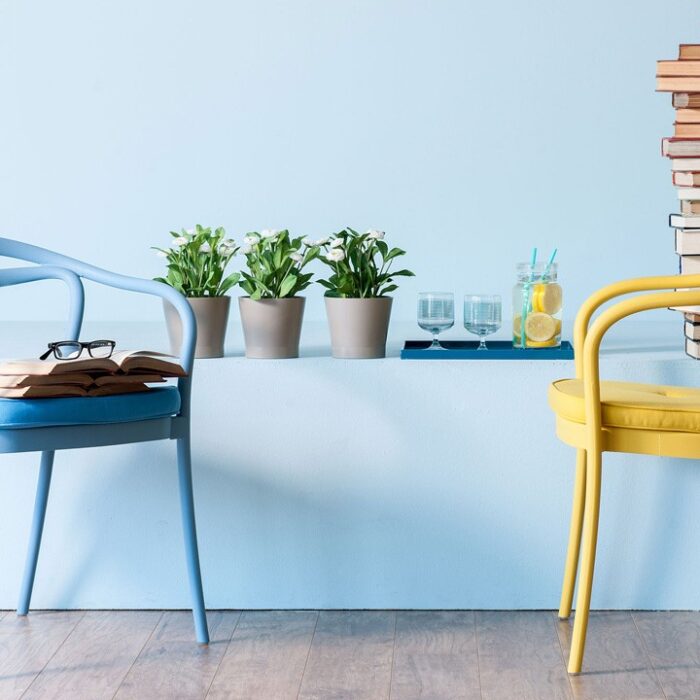 Blue and yellow chairs with books, plants.