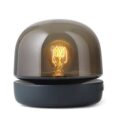 Modern lamp with glowing bulb inside.