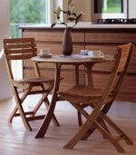 Wooden chairs and table with vase indoors.