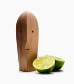 Wooden figure with sliced lime beside it.