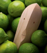 Wooden figure among fresh green limes.