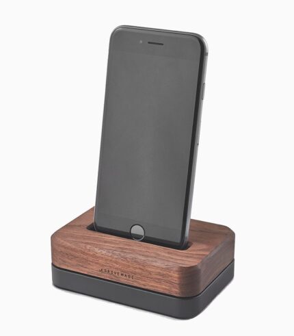Smartphone on wooden charging dock station.