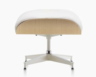 White cushioned ottoman with wooden base.