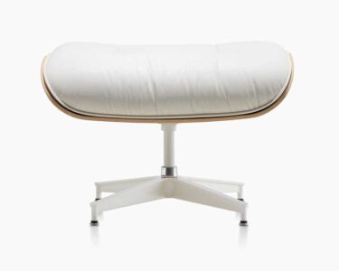 White cushioned ottoman with metal base.