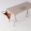 Wooden desk with laptop and storage hammock.