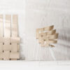 Woven wooden chairs in minimalist setting.