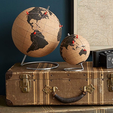 Cork globes on vintage suitcase with map.