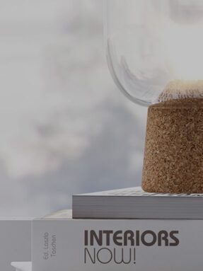 Glass lamp on stacked interior design books.