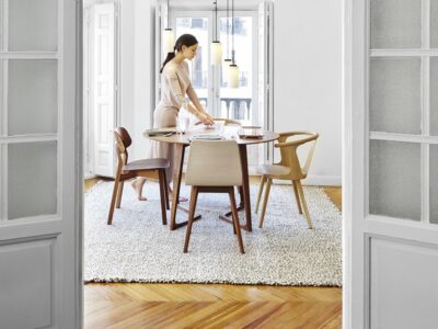 Woman setting table in elegant dining room.