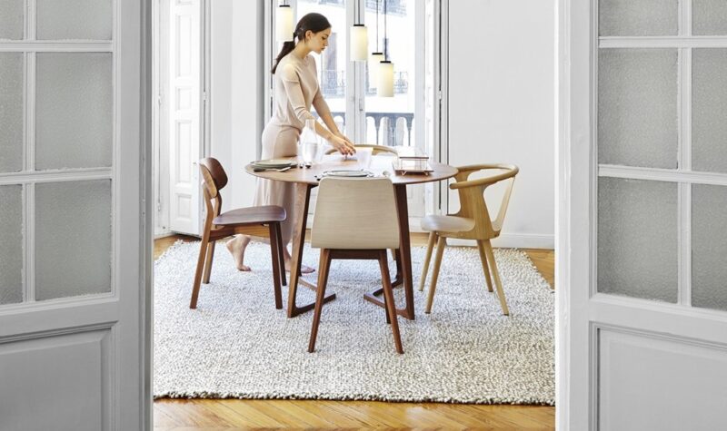 Woman setting table in elegant dining room.