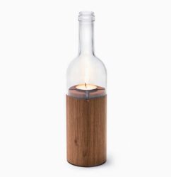 Wine bottle candle holder with lit candle.