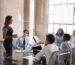 Business meeting with woman presenting to colleagues.