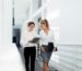 Two women walking in a bright hallway.