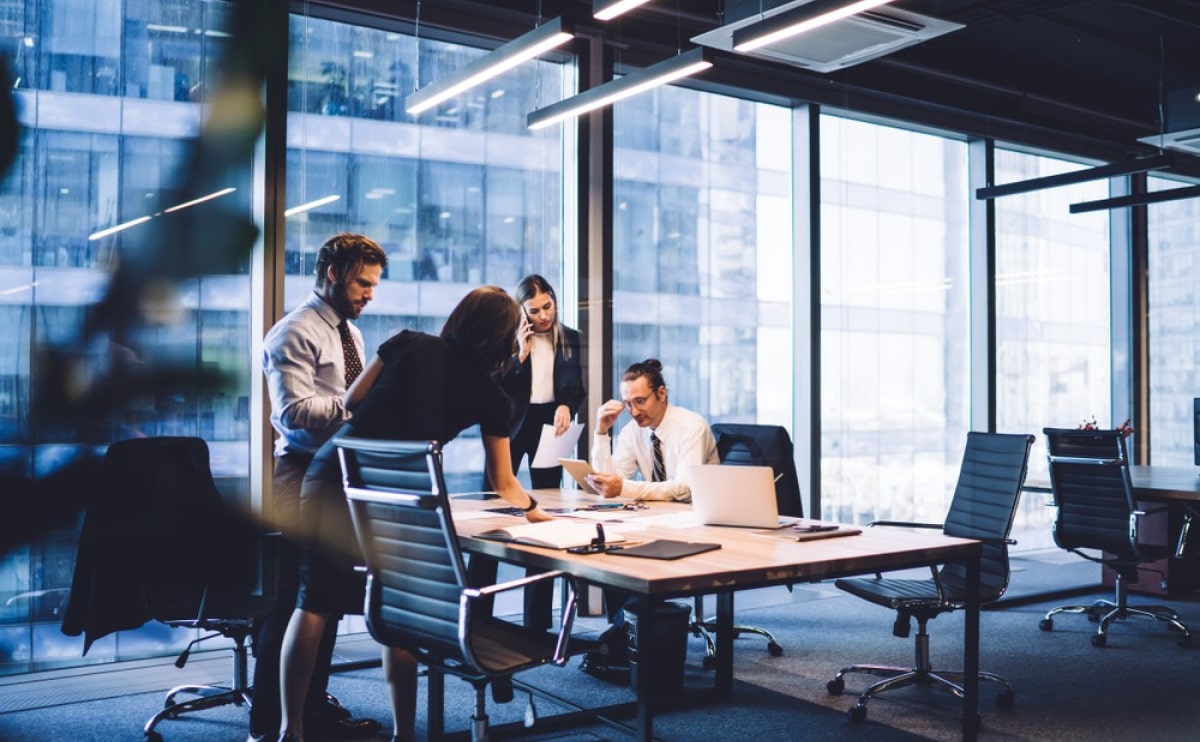 Team collaborating in modern glass-walled office.